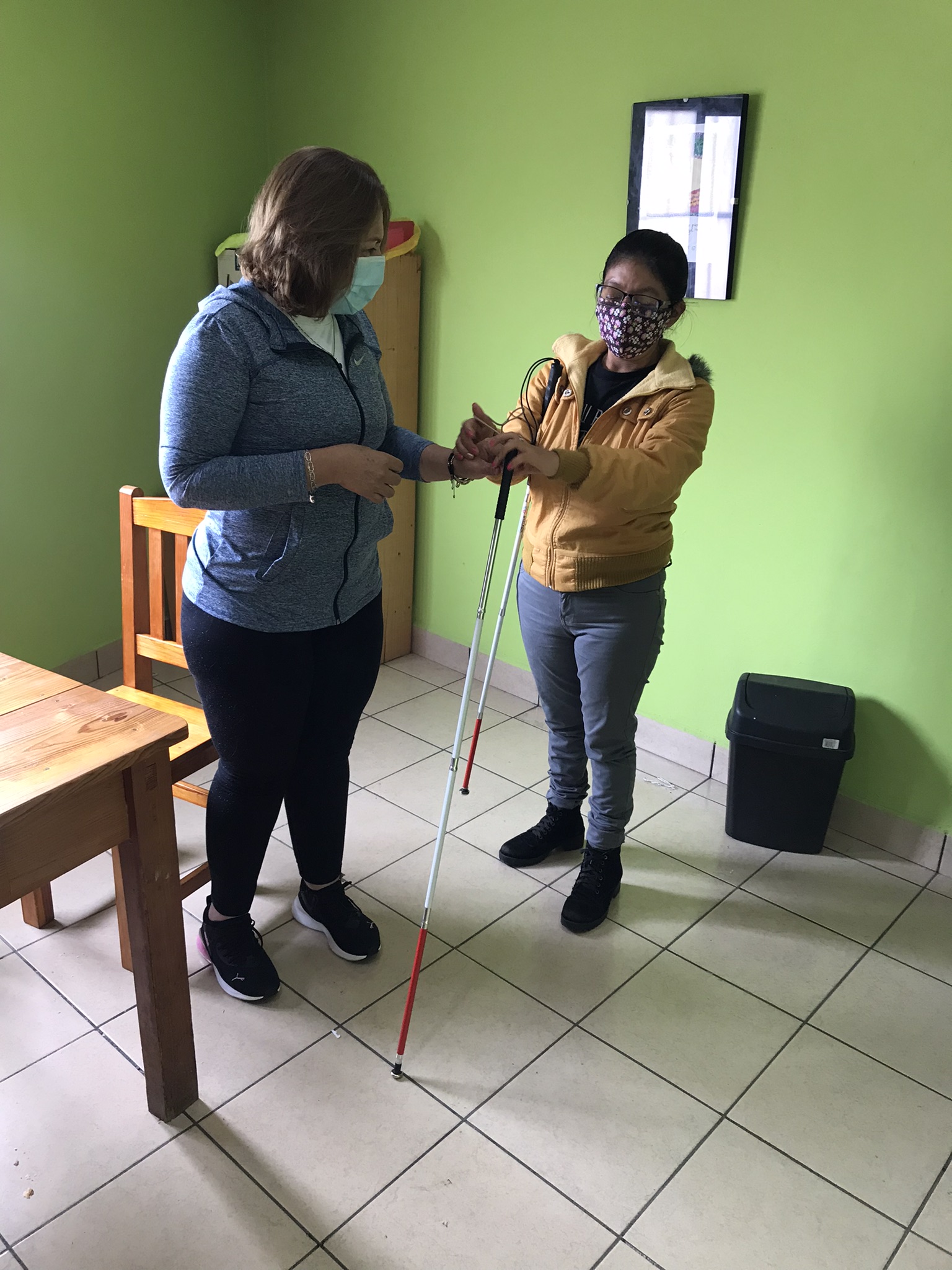 Instructora muestra como orientarse con el bastón blanco a mujer ciega