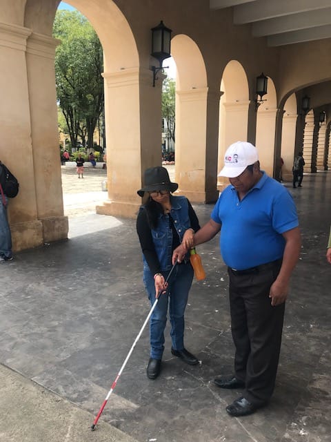 Instructora enseña a una persona ciega a usar el bastón blanco